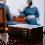 Pismo Święte i różaniec na drewnianym stole podczas spotkania wiernych