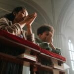 Samotna matka modli się z dzieckiem w jasnym, słonecznym kościele