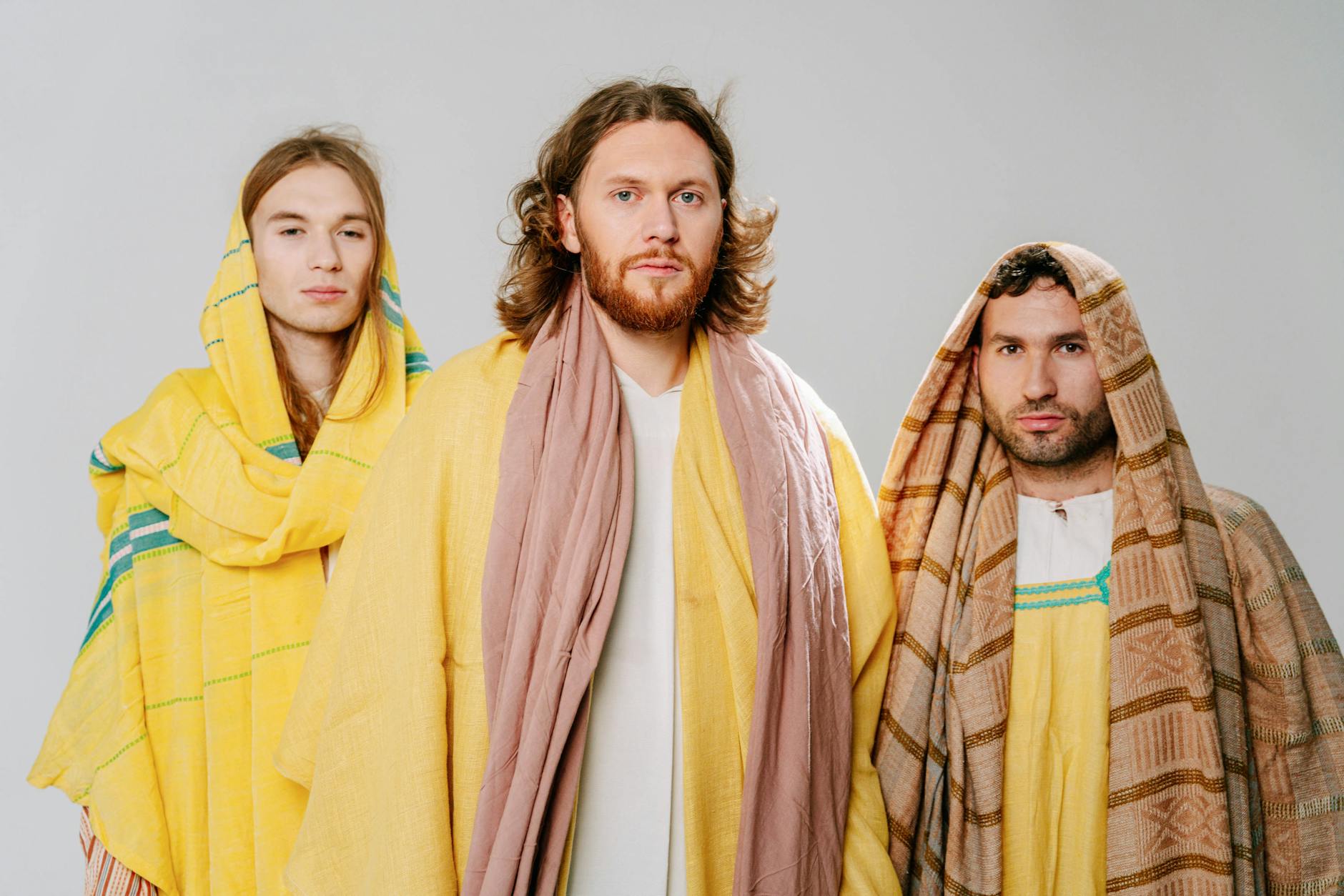 Trzech mężczyzn w szatach biblijnych w scence religijnej w pomieszczeniu