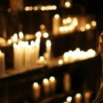 Złożone dłonie w modlitwie przy świecy w kościele w São Paulo