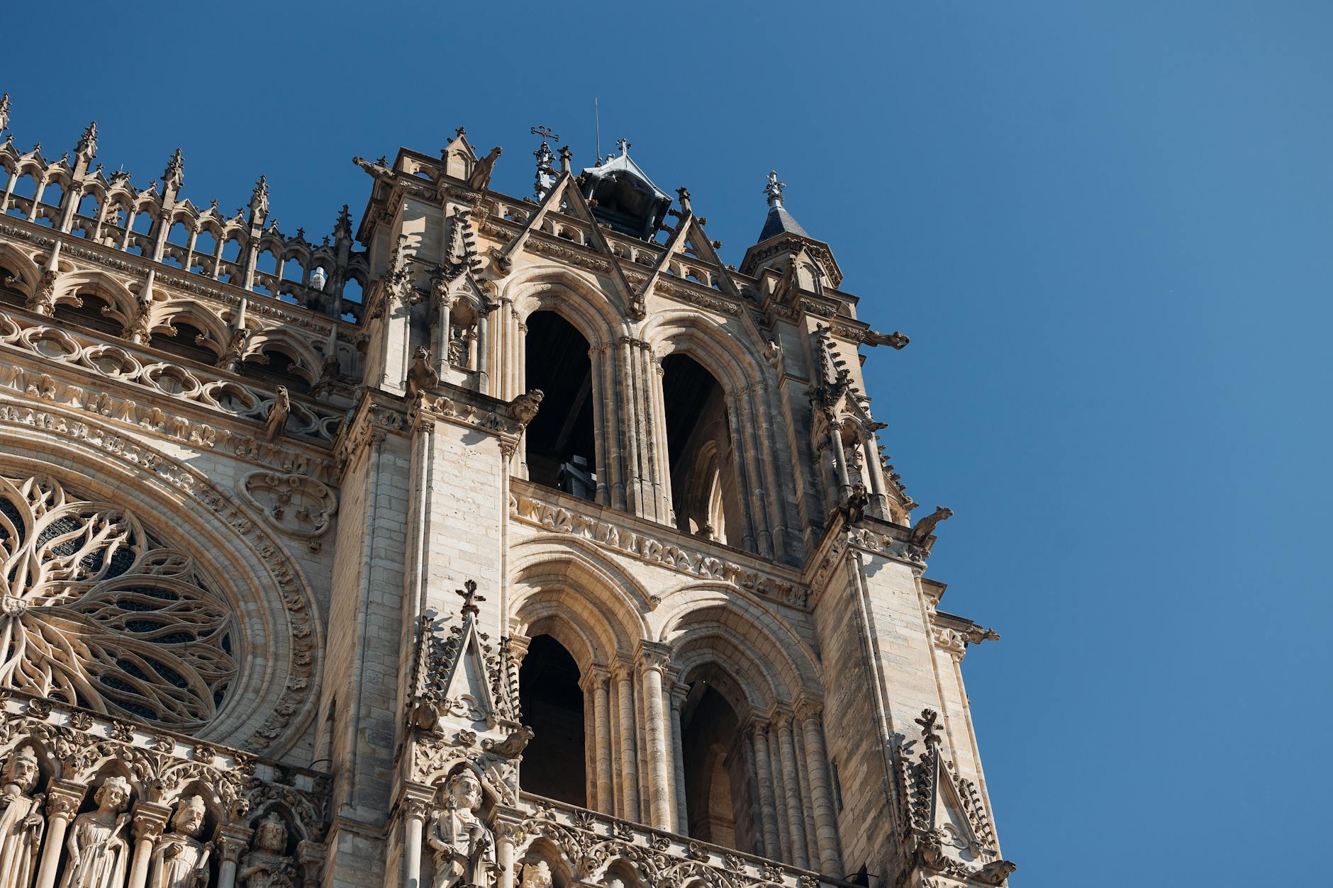 Detaliczna gotycka fasada katedry w Amiens na tle błękitnego nieba