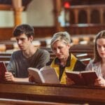 Jak zorganizować wieczór uwielbienia, który naprawdę prowadzi do spotkania z Bogiem Trzy osoby czytają Biblię razem w kościele podczas modlitewnego spotkania