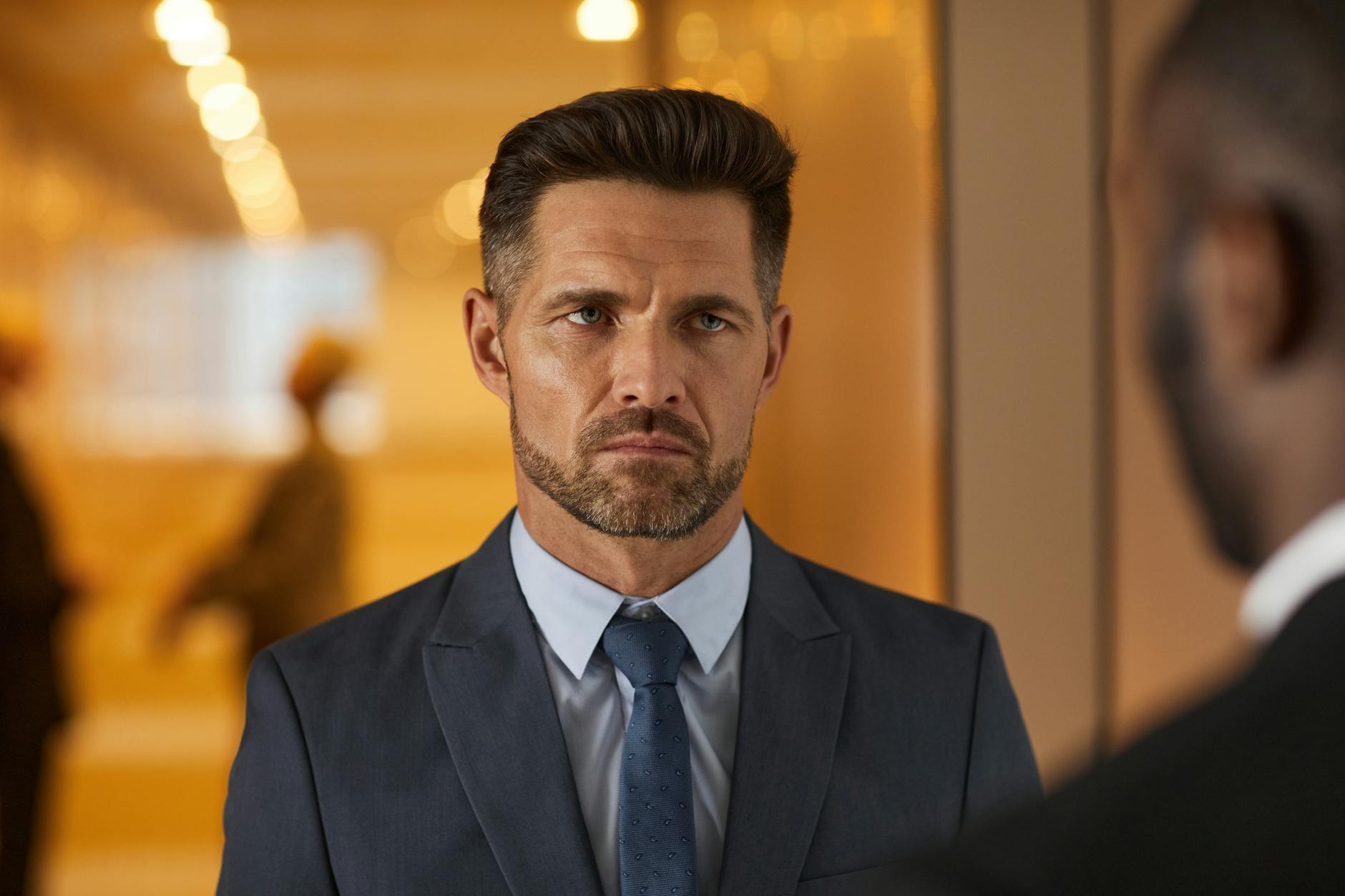 Jak żyć etyką chrześcijańską w pracy, gdy presja jest ogromna i nikt nie gra fair Zamyślony biznesmen w garniturze na rozmytym tle biura