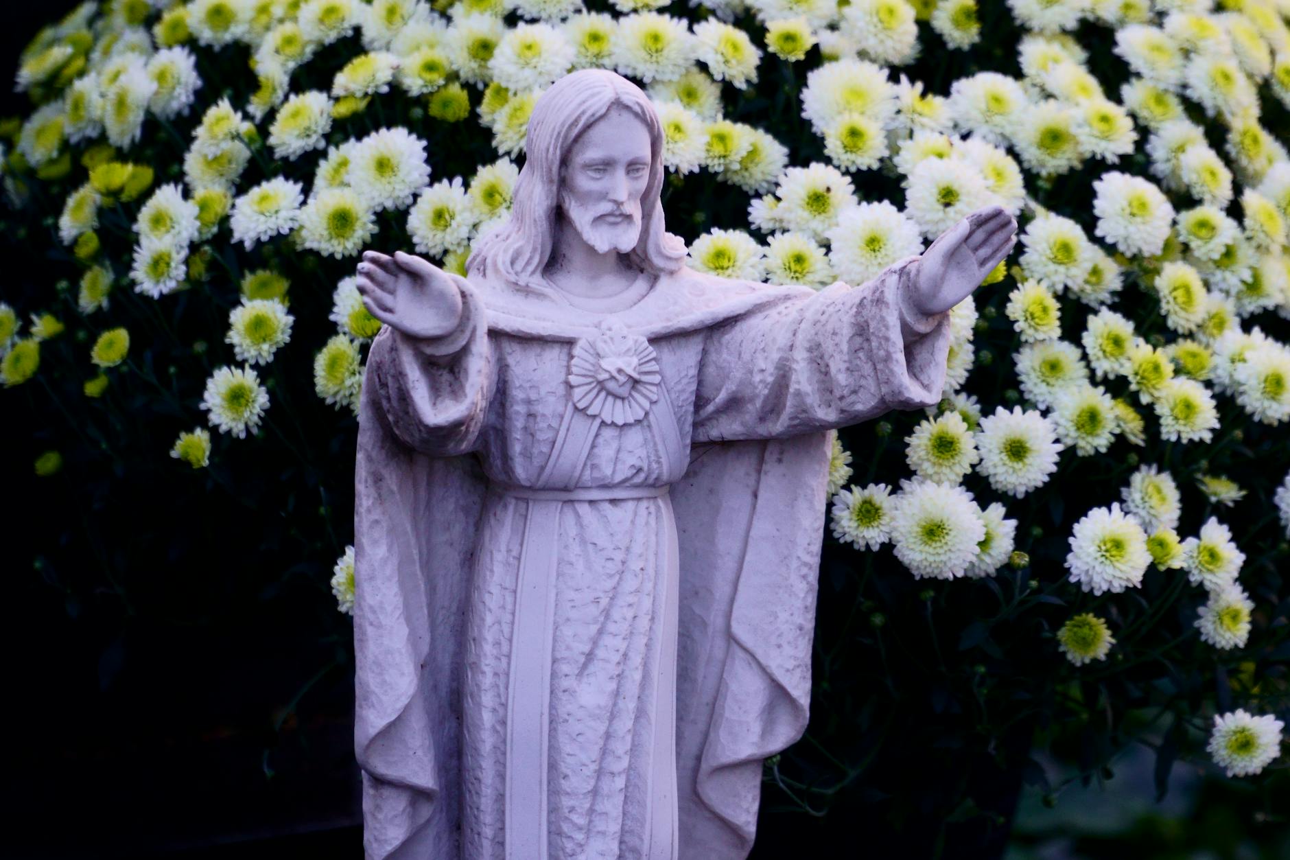 Figura Jezusa Chrystusa wśród kwitnących chryzantem