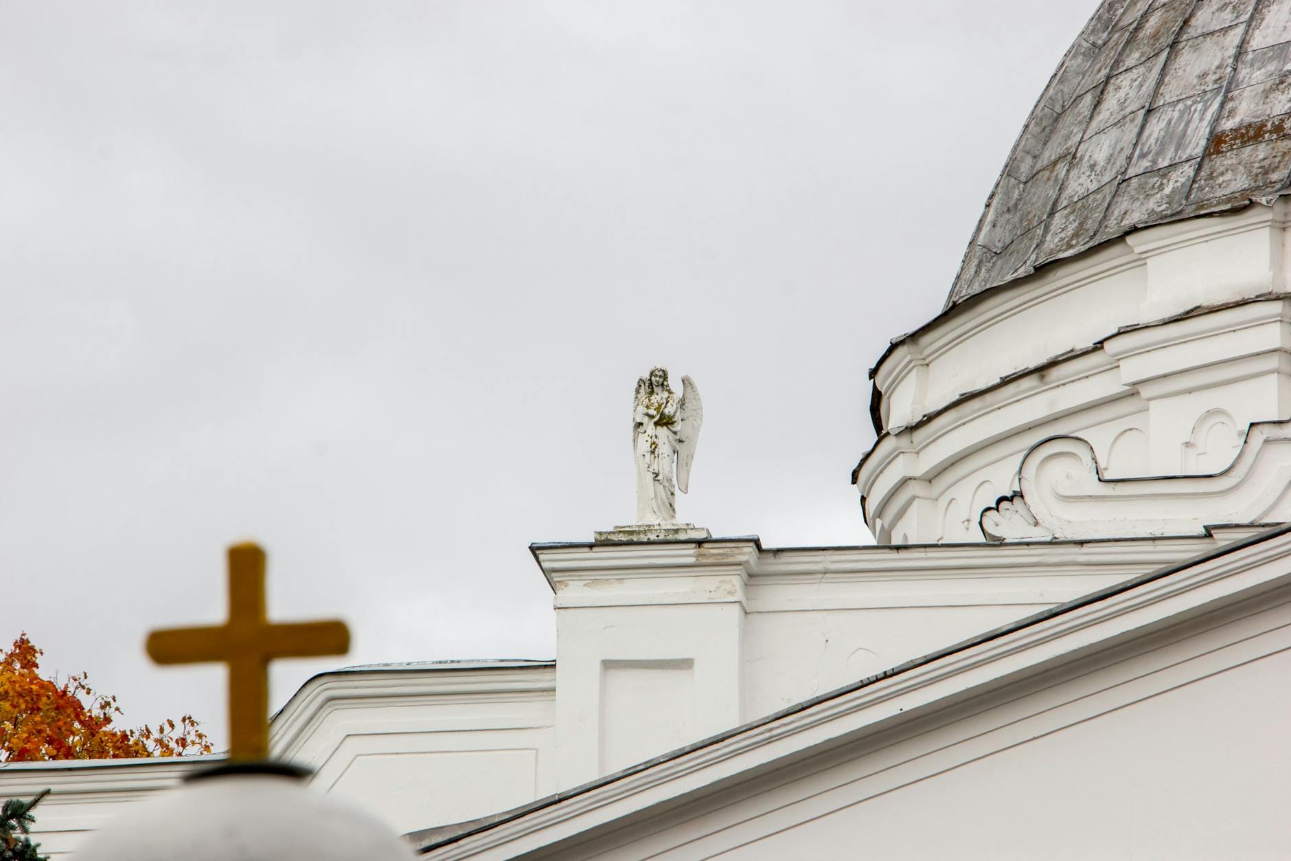Czy anioł może się objawić? Nauczanie Kościoła i relacje wiernych Posąg anioła i krzyż na tle kopuły kościoła