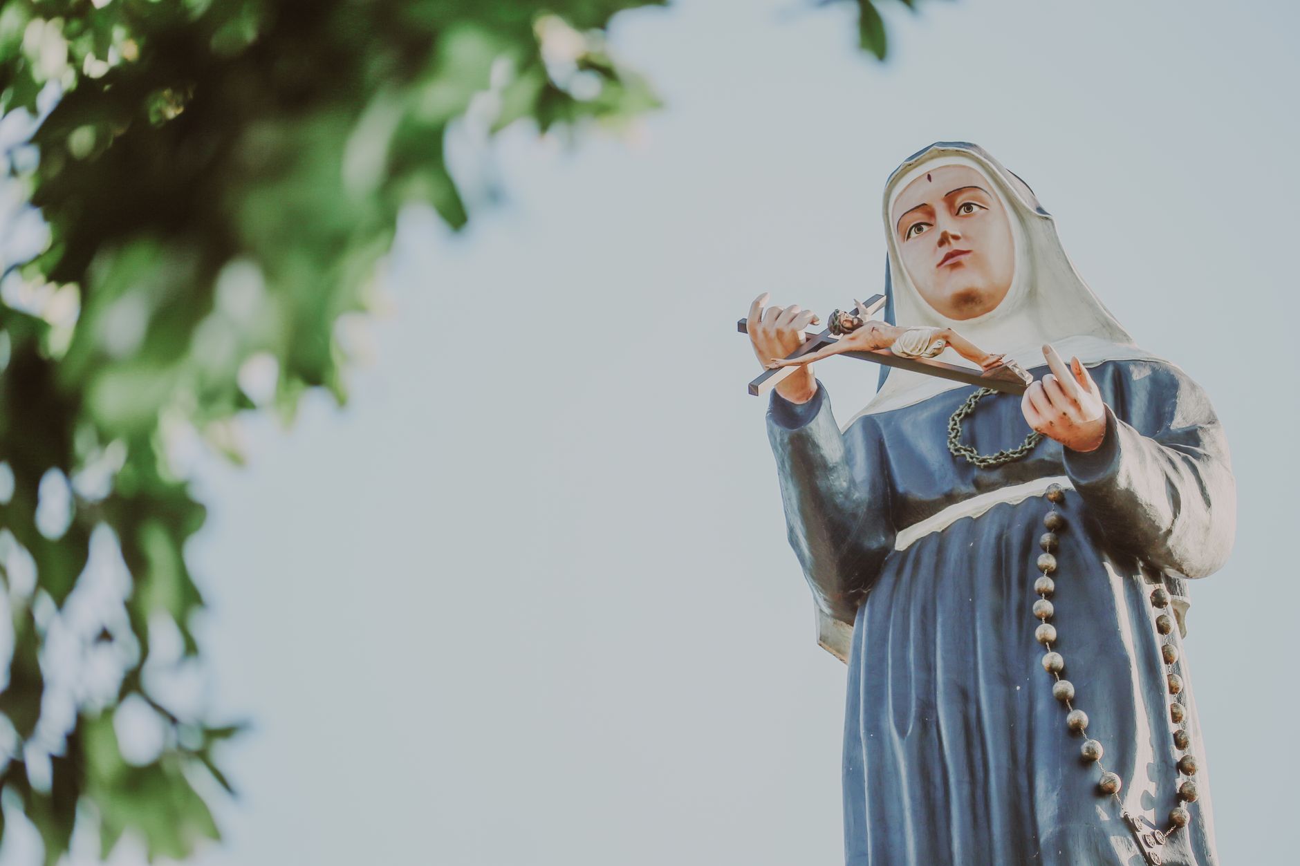 Święty Maksymilian Kolbe: miłość silniejsza niż strach Figura Maryi na tle błękitnego nieba