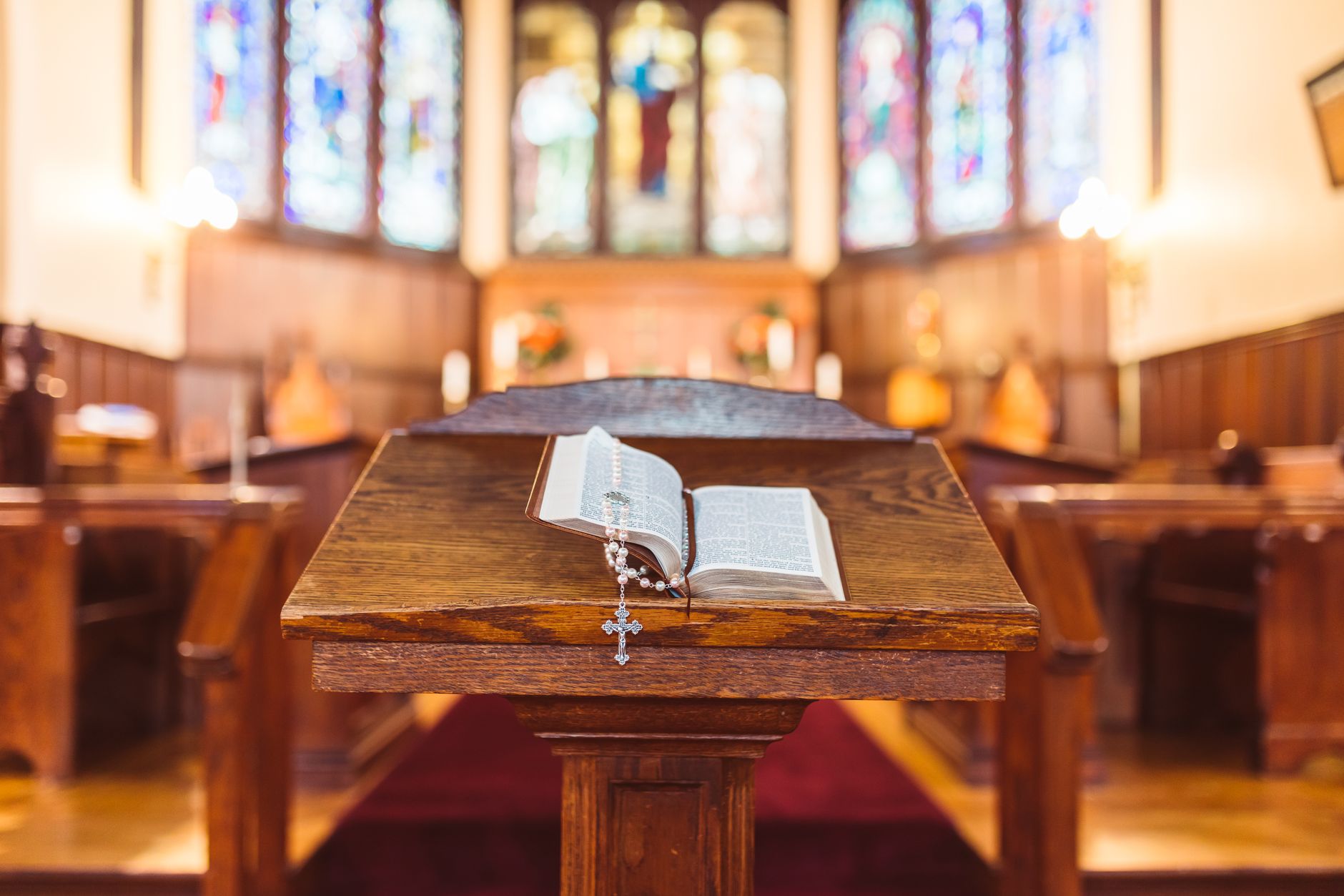 Otwarta Biblia i różaniec na drewnianej ambonie w kościele